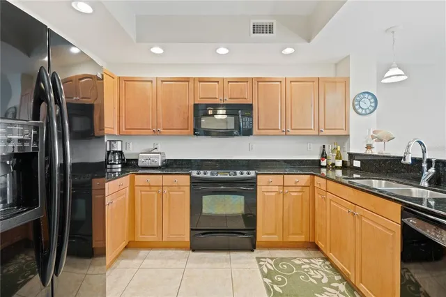 a kitchen with stainless steel appliances granite countertop a refrigerator stove and sink