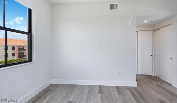 a view of an empty room with wooden floor