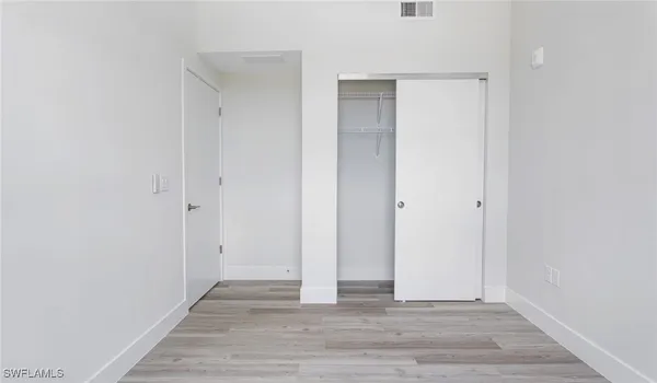 a view of an empty room with wooden floor