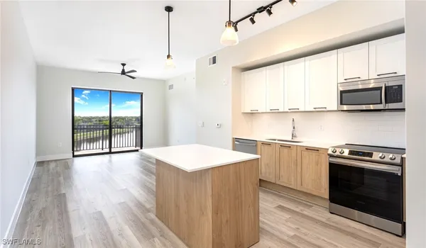 a kitchen with stainless steel appliances a stove a sink and a microwave