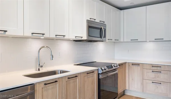 a kitchen with stainless steel appliances granite countertop a sink a stove and cabinets