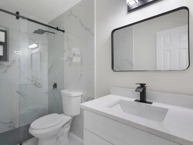 a bathroom with a sink a toilet and shower