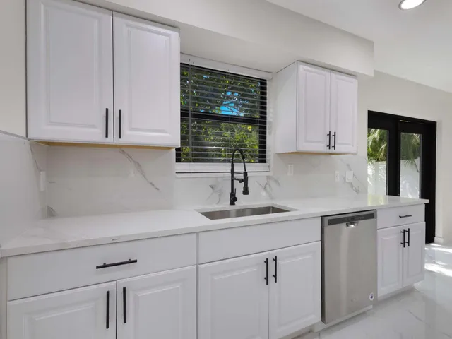 a kitchen with white cabinets and white appliances
