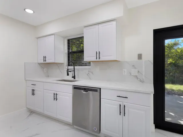 a kitchen with white cabinets and a sink