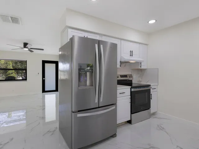 a kitchen with stainless steel appliances granite countertop a refrigerator and a stove