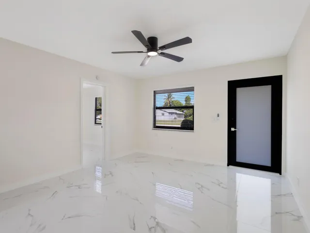 a view of a livingroom with a ceiling fan and window