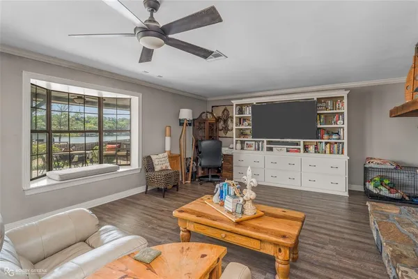 a living room with furniture a flat screen tv and wooden floor