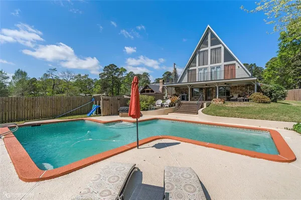 a view of a house with swimming pool and a yard