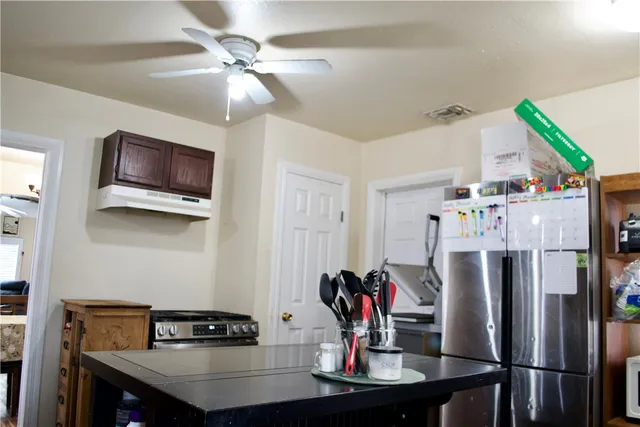 a kitchen with stainless steel appliances a dining table and chairs