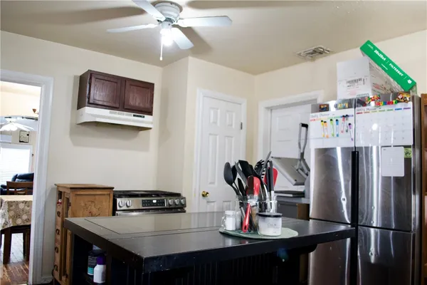 a kitchen with stainless steel appliances a dining table and chairs