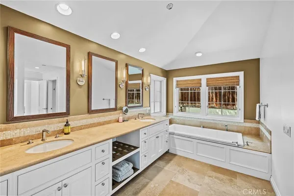 a bathroom with a tub sink and mirror