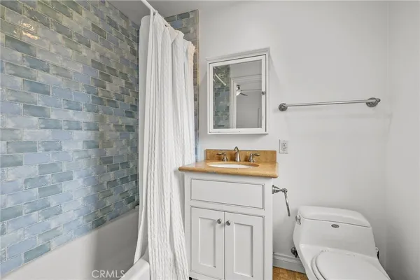 a bathroom with a granite countertop toilet a sink and a bathtub