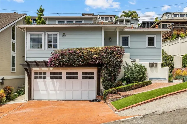 a front view of a house with a garden