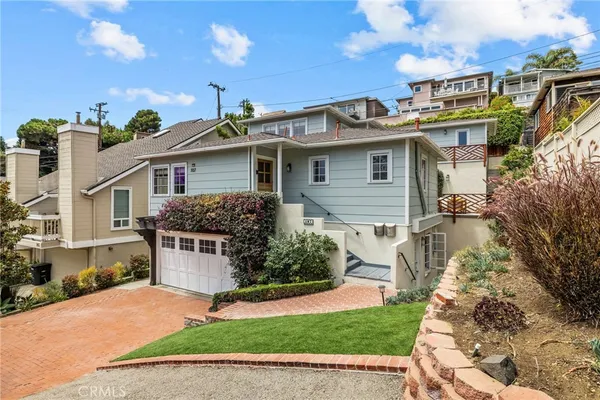 a front view of a house with a yard and potted plants