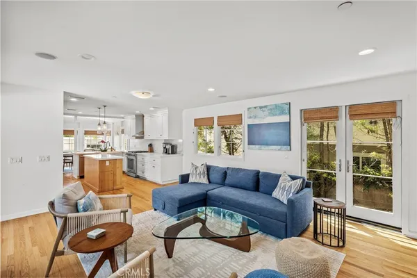 a living room with furniture and a dining table with wooden floor