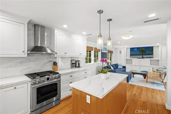 a large kitchen with sink a stove and chairs