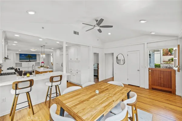 a living room with stainless steel appliances furniture and wooden floor