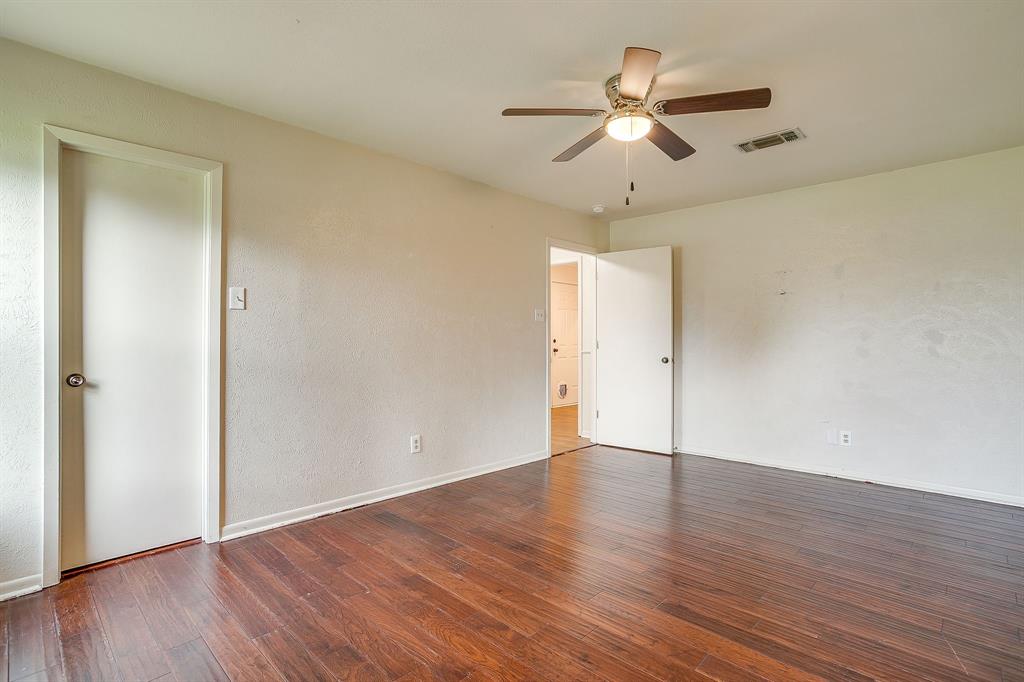 709 North Ave B Springtown, TX 76082 - Photo 24 of 32 an empty room with wooden floor ceiling fan and windows