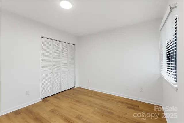 a view of a hallway with wooden floor and entryway
