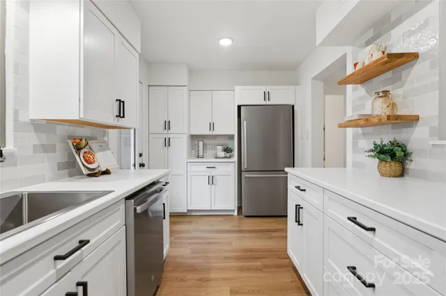 a kitchen with refrigerator a sink and wooden cabinets