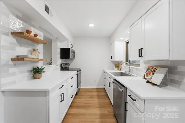 a kitchen with a sink and wooden floor