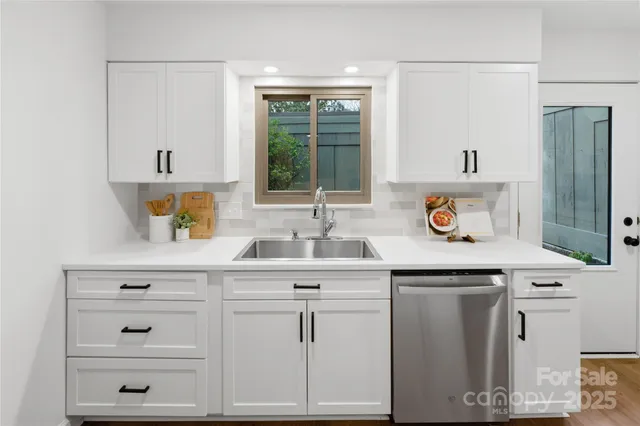 a sink with cabinets and window