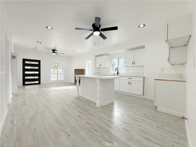 a view of a kitchen with a sink dishwasher a refrigerator and wooden floor