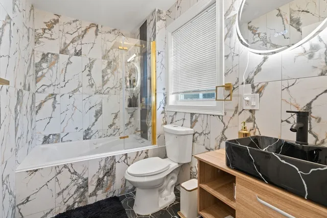 a white toilet sitting next to a bathroom sink