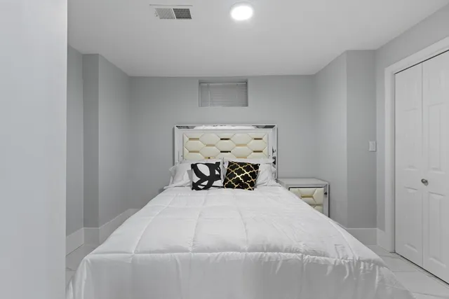 a bed sitting in a bedroom next to a window