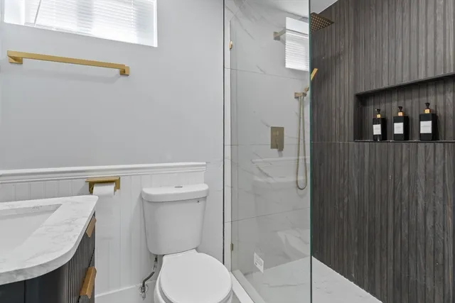 a bathroom with a sink a toilet and shower