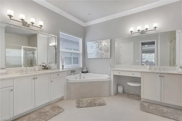 a spacious bathroom with a double vanity sink mirror and bathtub