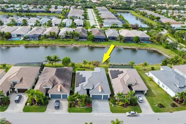 an aerial view of residential houses with outdoor space and lake view