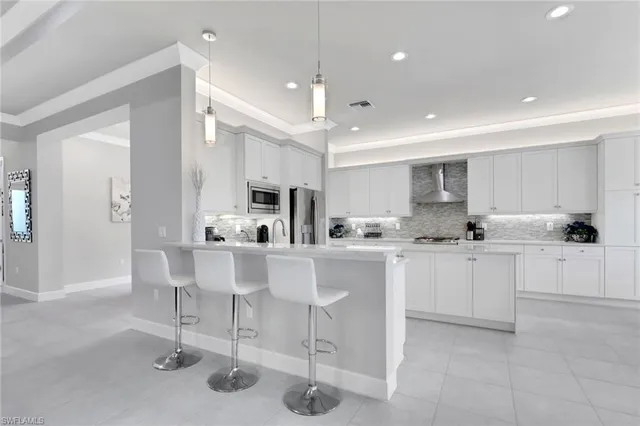 a kitchen with stainless steel appliances kitchen island granite countertop a table and chairs in it