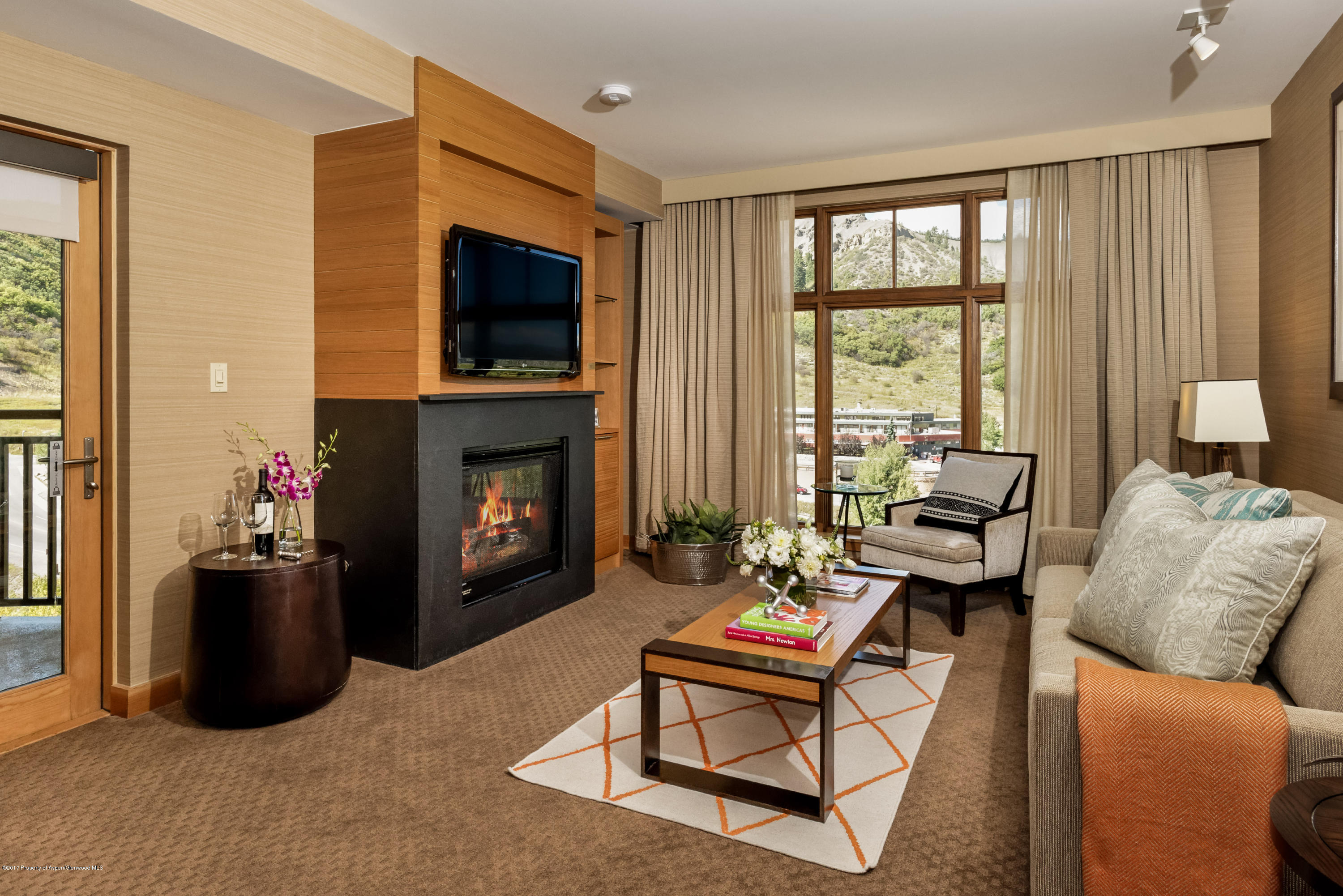 130 Wood Road, Unit 614 Snowmass Village, CO 81615 - Photo 2 of 11 a living room with furniture a flat screen tv and a fireplace