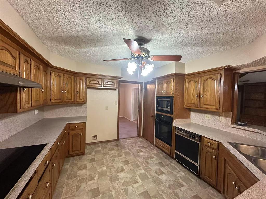 4726 Berridge Lane Dallas, TX 75227 - Photo 5 of 12 a kitchen with stainless steel appliances granite countertop a refrigerator a stove and a sink with cabinets