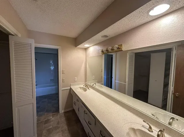 a bathroom with a double vanity sink and mirror