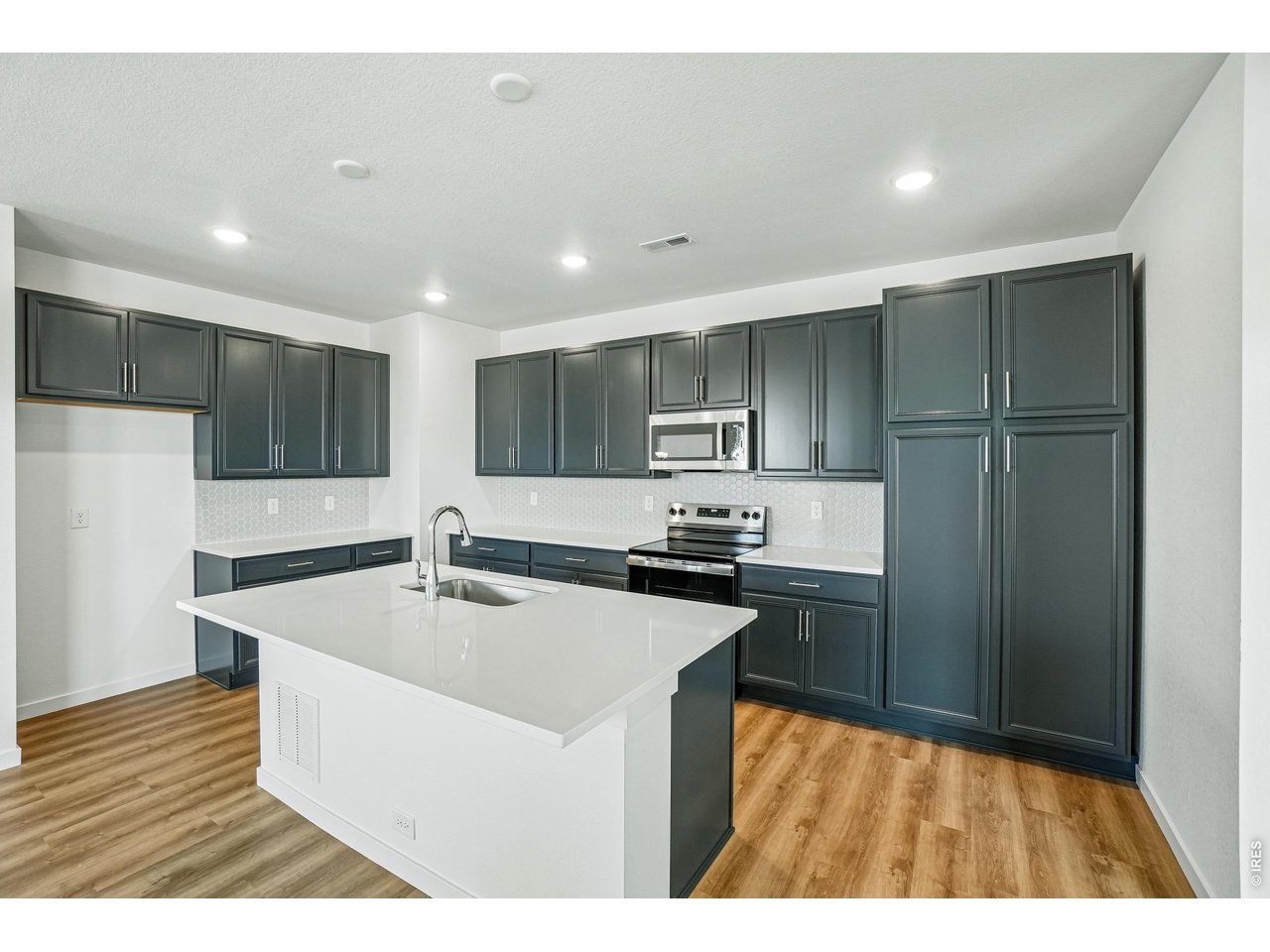 4516 Burl Street Timnath, CO 80547 - Photo 15 of 46 Large kitchen with white quartz countertop and dark cabinets