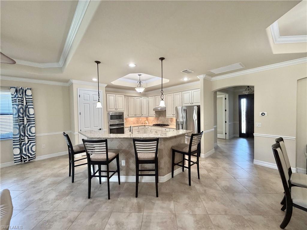 2930 Aviamar Circle Naples, FL 34114 - Photo 14 of 39 a dining area with a table chairs and a kitchen view