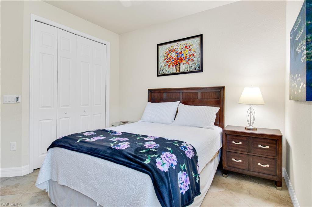 2930 Aviamar Circle Naples, FL 34114 - Photo 21 of 39 a bedroom with a bed a lamp and a window