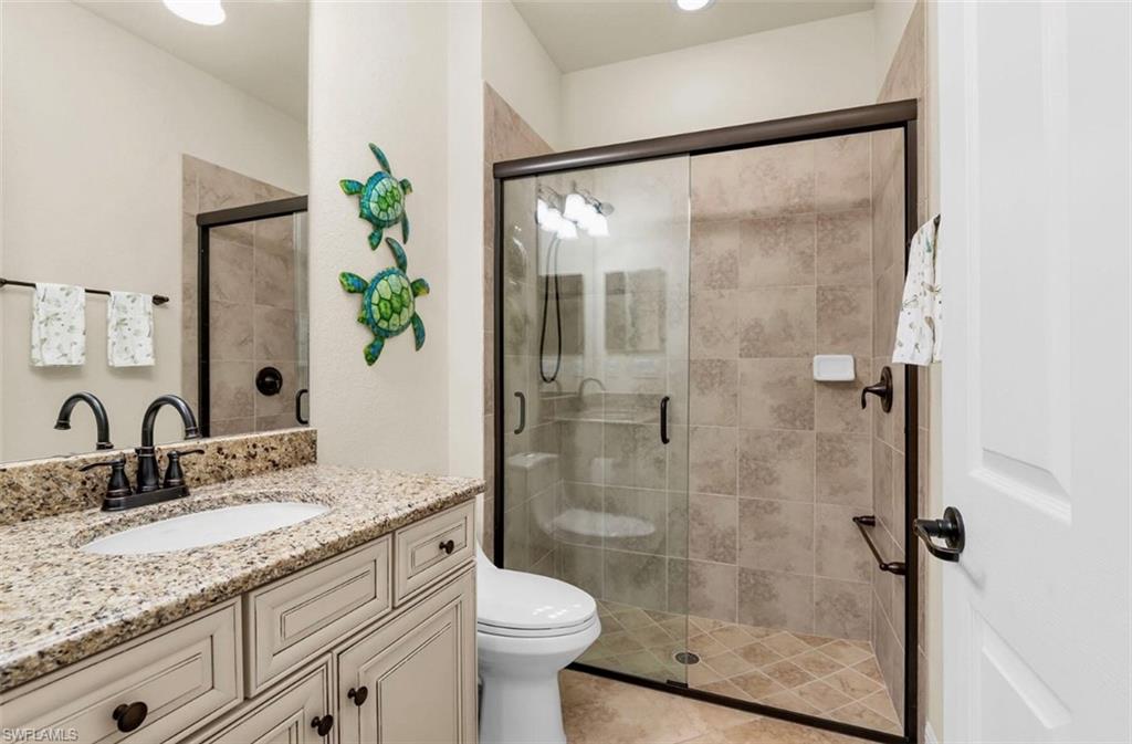 2930 Aviamar Circle Naples, FL 34114 - Photo 22 of 39 a bathroom with a granite countertop sink a toilet and shower