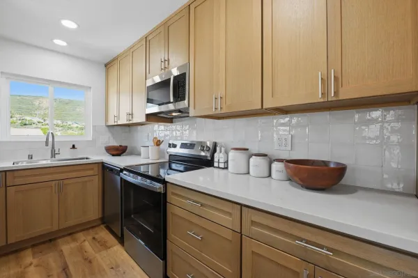 a kitchen with stainless steel appliances granite countertop a sink a stove and a microwave