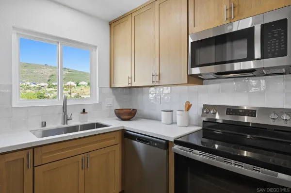 a kitchen with stainless steel appliances granite countertop a sink stove and microwave