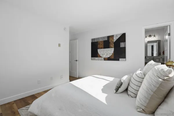 a bedroom with a bed and a painting on the wall