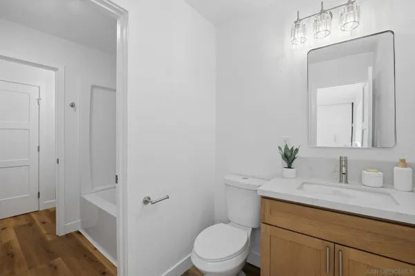 a bathroom with a granite countertop sink a toilet and a mirror
