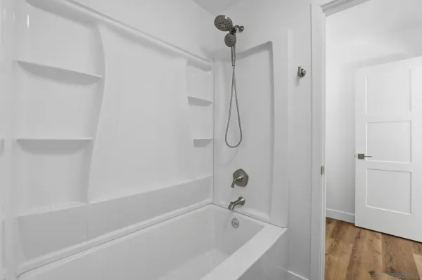 a bathroom with a bath tub with a shower