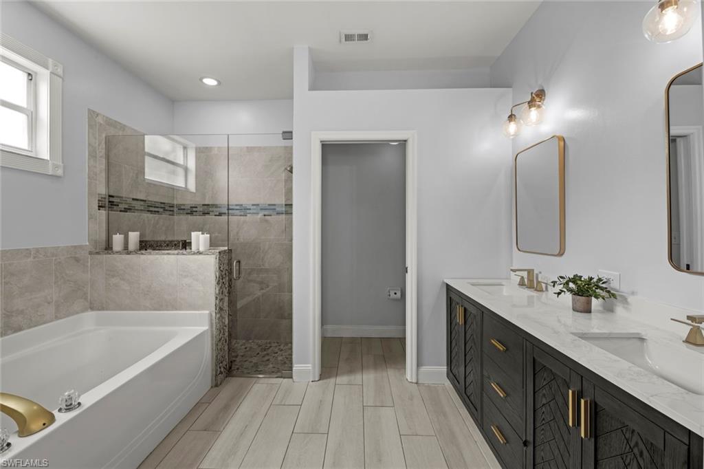 21778 Brixham Run Loop Estero, FL 33928 - Photo 18 of 48 a bathroom with a bathtub double vanity sink and mirror