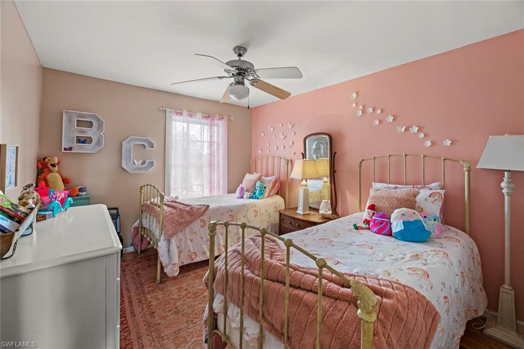 21778 Brixham Run Loop Estero, FL 33928 - Photo 22 of 48 a bedroom with a bed and a chandelier