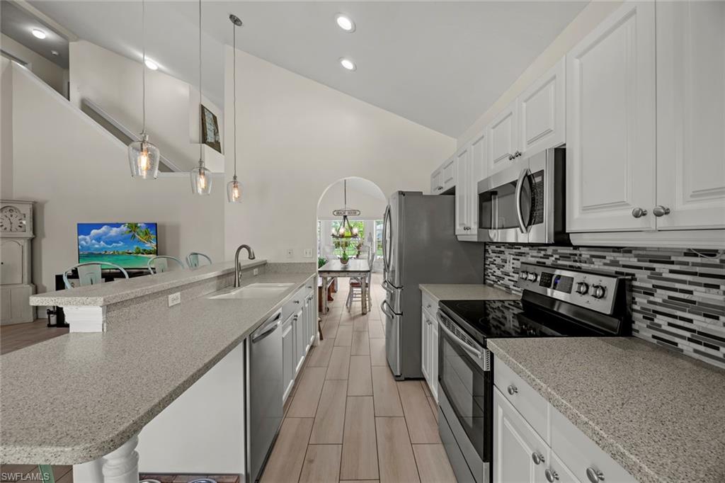 21778 Brixham Run Loop Estero, FL 33928 - Photo 5 of 48 a large kitchen with stainless steel appliances granite countertop a lot of counter space and wooden floor