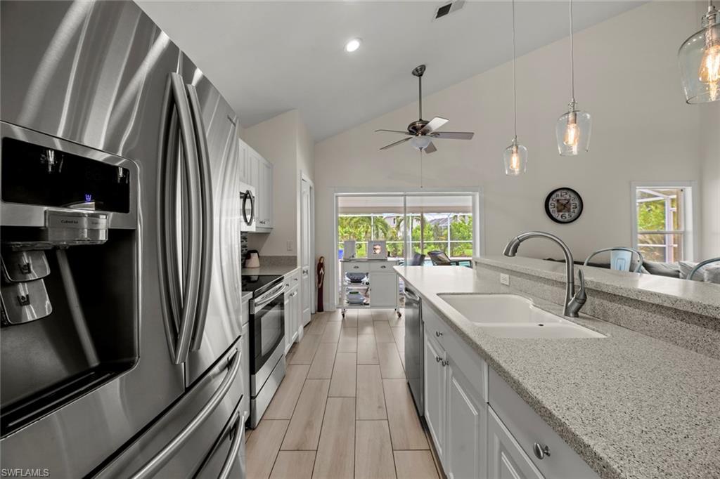 21778 Brixham Run Loop Estero, FL 33928 - Photo 7 of 48 a large kitchen with a sink stainless steel appliances and a counter top space