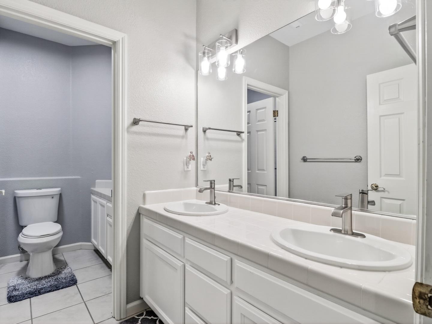 9123 Rancho Hills Drive Gilroy, CA 95020 - Photo 11 of 26 a bathroom with a sink a toilet and a mirror